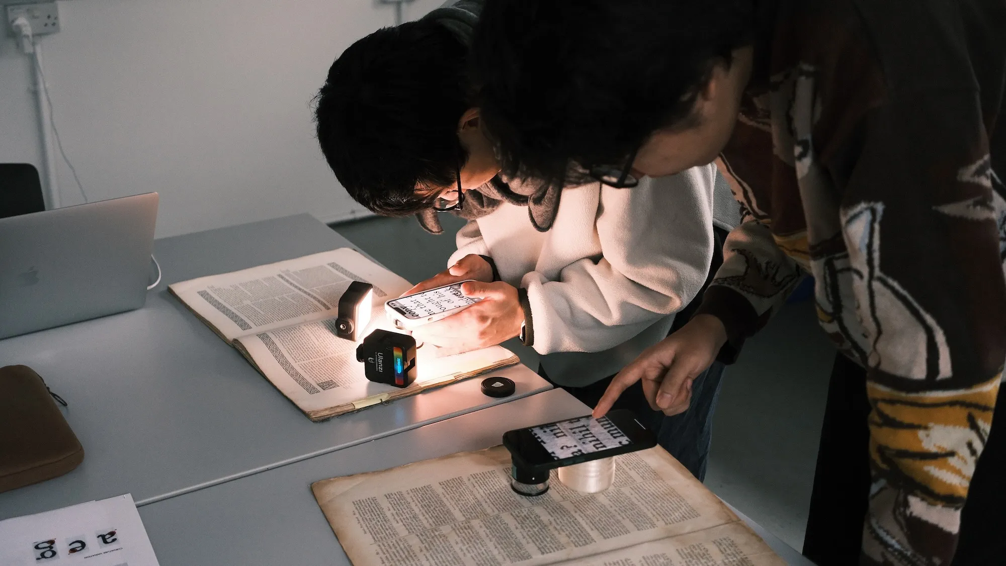 復刻ワークショップ、文献を拡大鏡で見ている時の様子